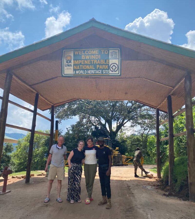 Travellers and their guide at the entrance gate to Bwindi Impenetrable National Park, Uganda