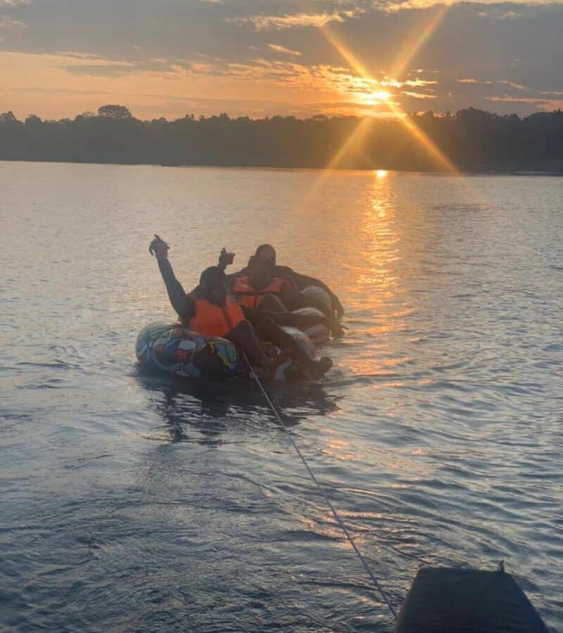 Travellers floating on tubes on the Nile at sunset near Jinja, Uganda