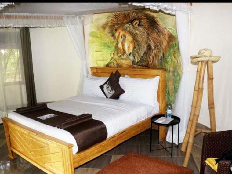 A lodge bedroom with a painted lion mural above the bed